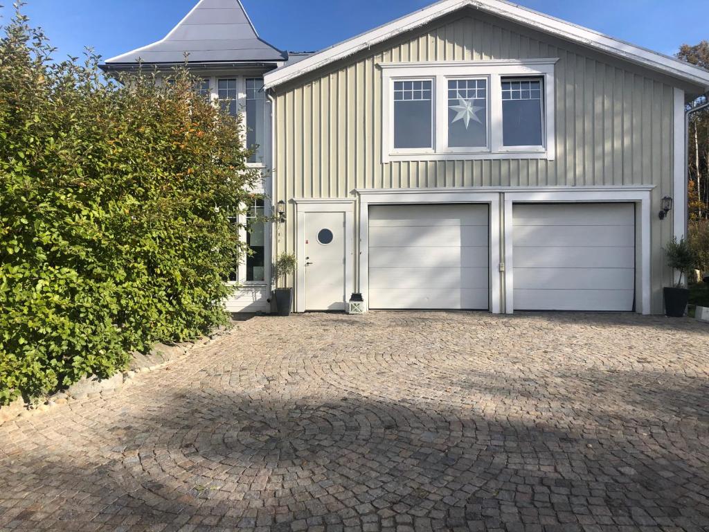 a house with two garage doors and a driveway at Villa Båthamnsgatan in Söråker