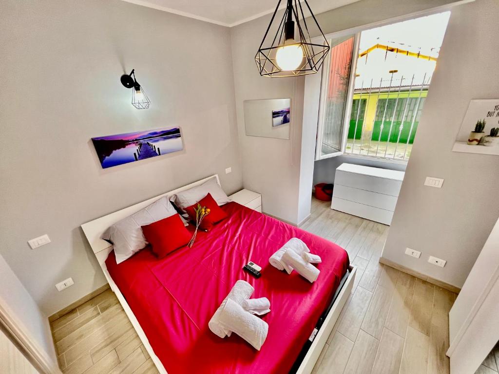 a bedroom with a red bed with towels on it at Accogliente appartamento a due passi dalla metro in Moncalieri
