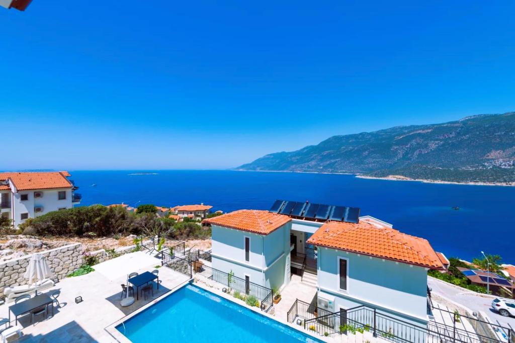 a villa with a swimming pool and a view of the ocean at Gümüş Yazar Hotel in Kaş