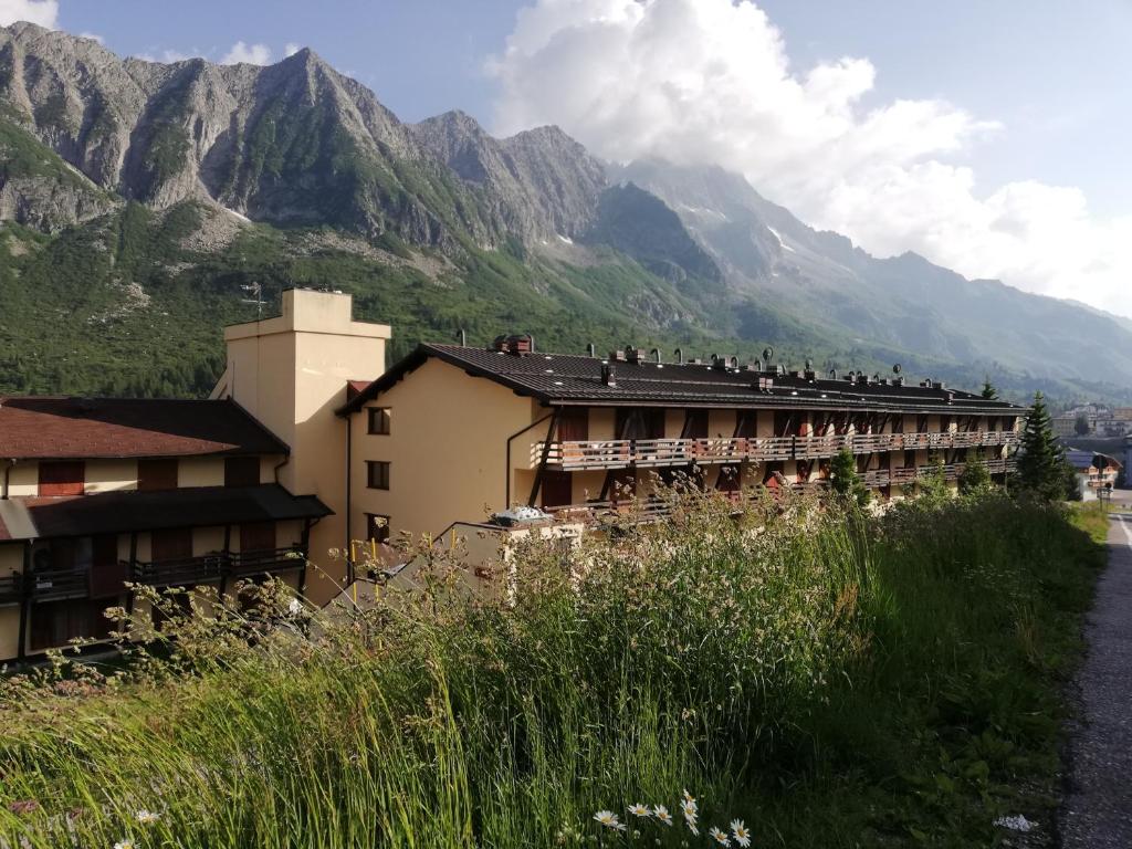 budynek z ludźmi siedzącymi na dachu i górami w tle w obiekcie DONCIO`S Ski Hike & Bike Apartment w mieście Passo del Tonale