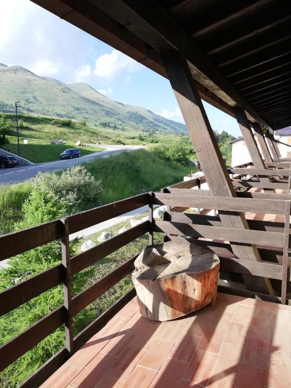 drewniany płot z pniakiem drzewa stojący na ganku w obiekcie DONCIO`S Ski Hike & Bike Apartment w mieście Passo del Tonale
