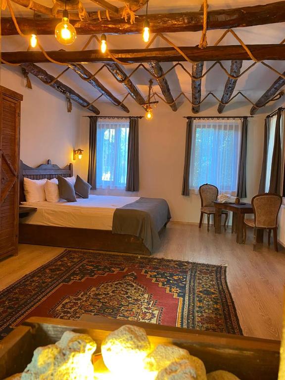 a bedroom with a large bed and a table and chairs at Kapadokya Konak in Uçhisar