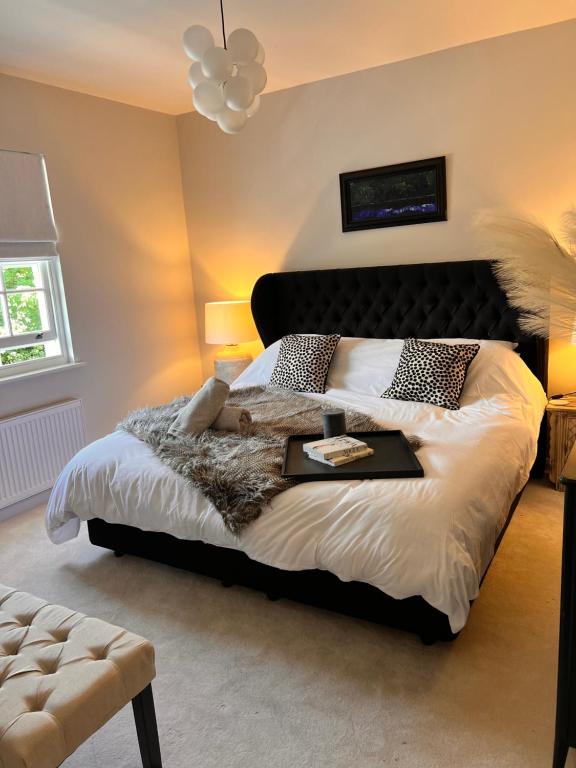 a bedroom with a large bed with a black headboard at Three Acorns Court in Sandwich