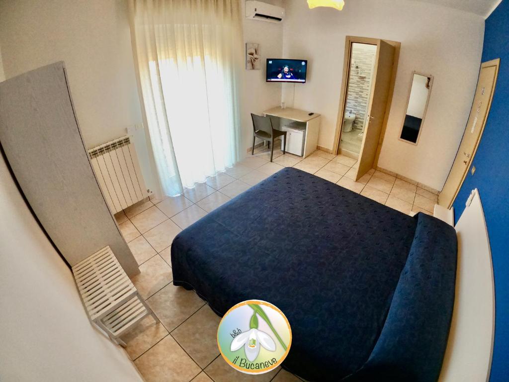 コリリアーノ・カーラブロにあるB&B Il Bucaneveのベッドルーム(青いベッド1台、デスク付)が備わります。
