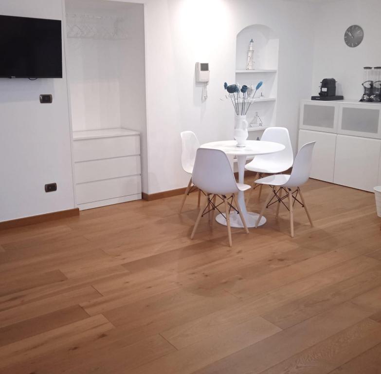jadalnia z białym stołem i białymi krzesłami w obiekcie B&B Verdi w mieście Brindisi