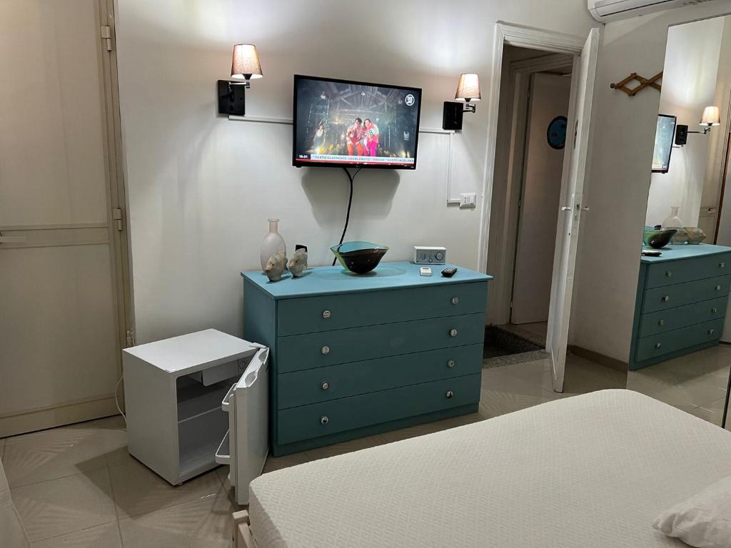 ein Schlafzimmer mit einer blauen Kommode und einem TV an der Wand in der Unterkunft Casa Vacanza Giovanna nr 52 contrada Mezzacampa località Caporasocolmo Messina in Messina