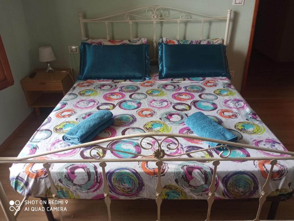 a bed with blue pillows and a colorful bedspread at KING PRIVATE ROOM TRA ARTE MARE CAMPAGNA in Empoli