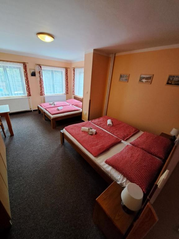 a room with two beds and two tables in it at U Bernardýna in Harrachov