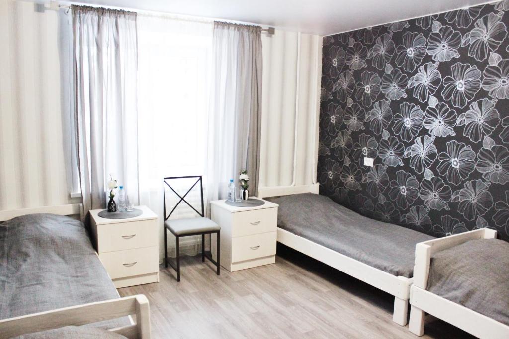 a bedroom with two beds and a black and white wallpaper at Stars Hostel in Yaroslavl