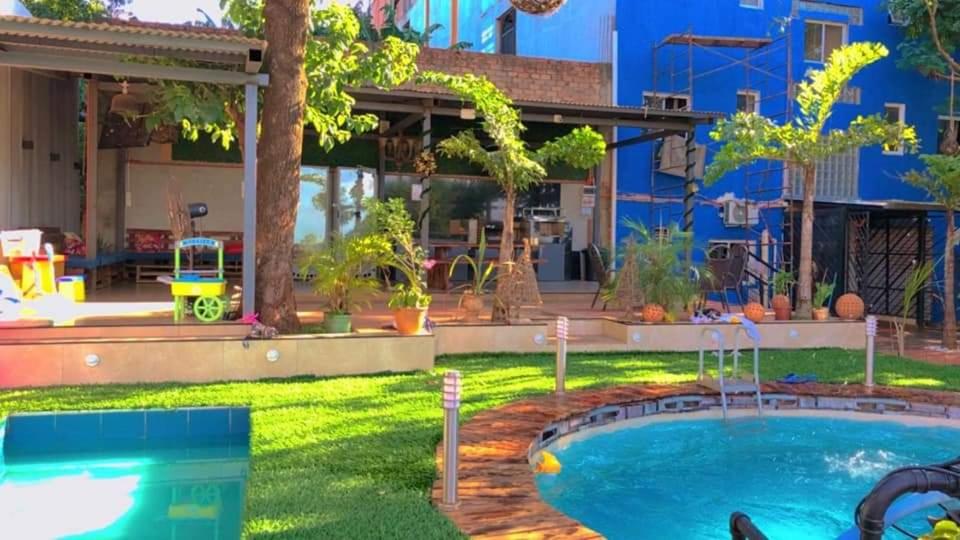 a backyard with a swimming pool and a house at Los Monges Aparthotel in Ciudad del Este