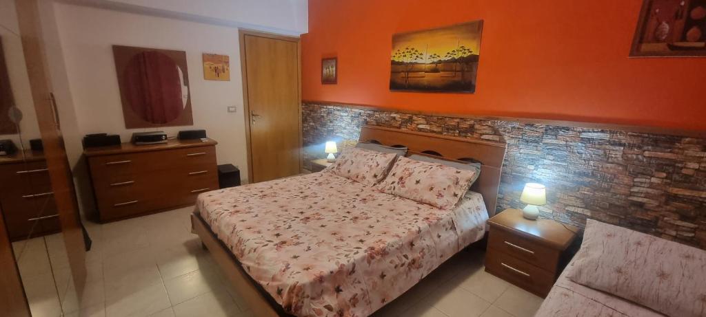 ein Schlafzimmer mit einem Bett und einer Ziegelwand in der Unterkunft Appartamento in Complesso Sonia in Santa Teresa di Riva