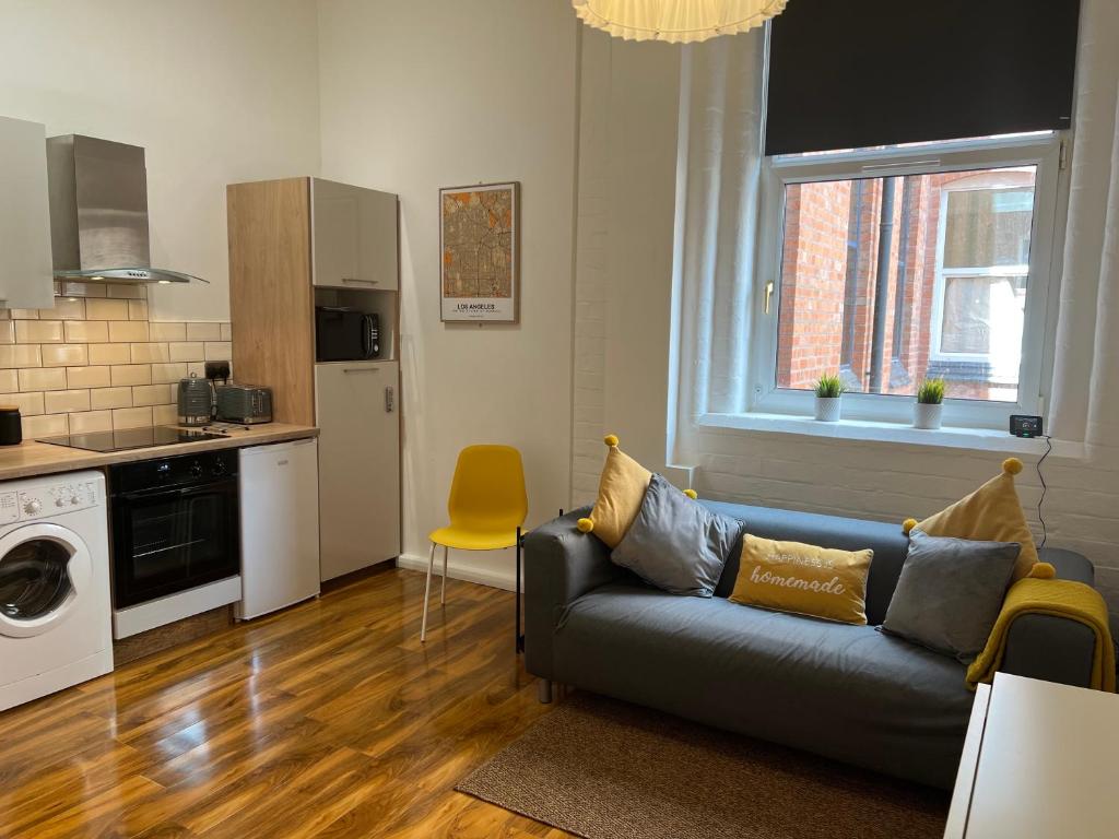 a living room with a couch and a kitchen at Cosy Apartment in the Heart of Leicester in Leicester