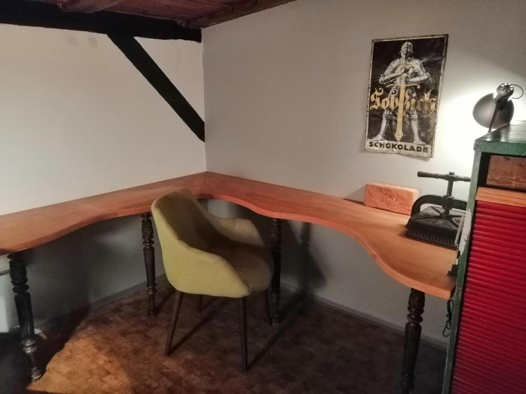 escritorio de madera en una habitación con silla en Art Apartament Puszczykowo, en Puszczykowo