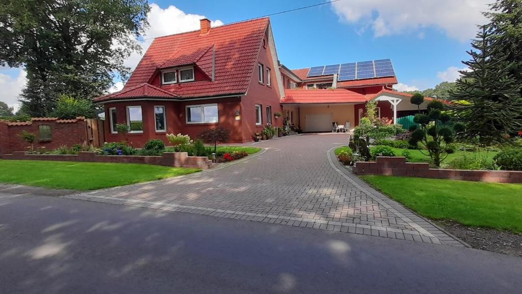 ein Haus mit rotem Dach und Auffahrt in der Unterkunft Ferienwohnung Rita in Grönheim
