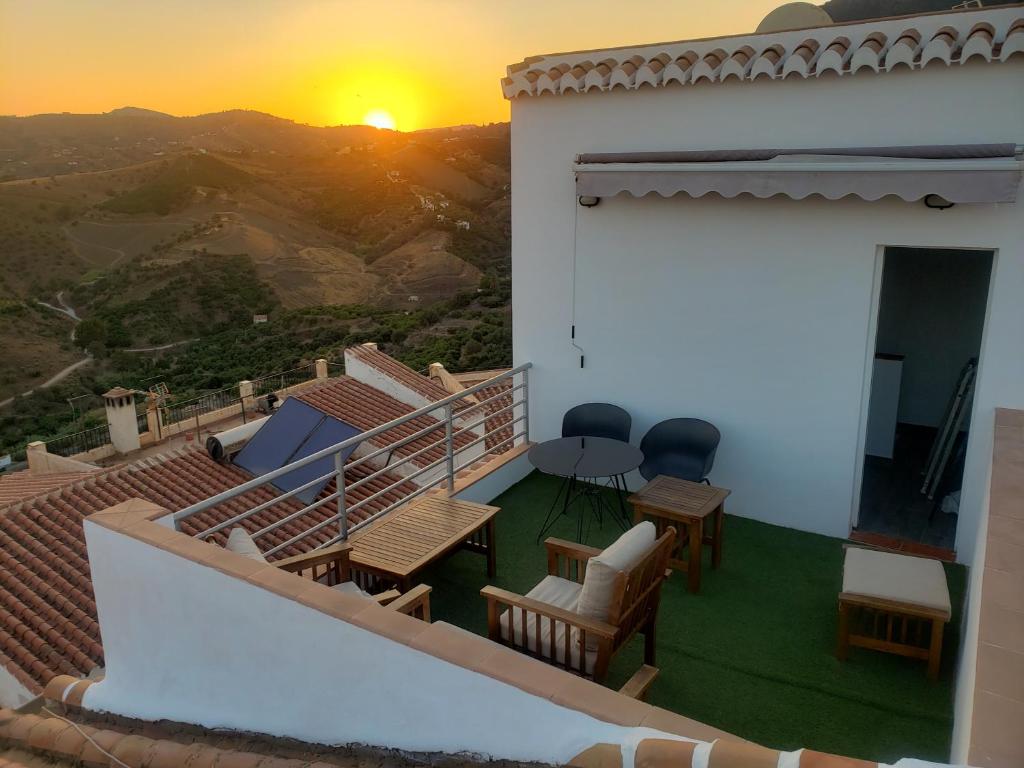 a balcony of a house with a sunset in the background at Loft of Love in Frigiliana