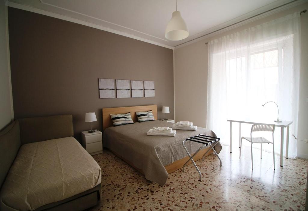 a bedroom with a bed and a table and a window at Giuffrida Apartment Rooms in Catania