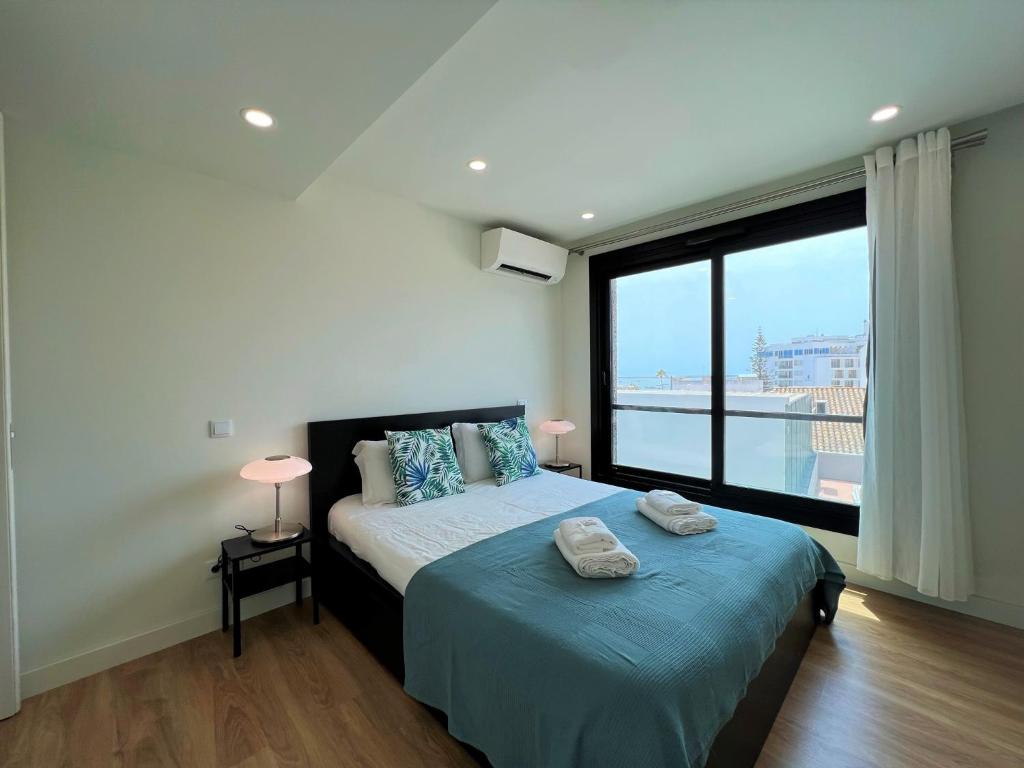 una camera con un letto e una grande finestra di Faro Design 2 by Homing a Faro