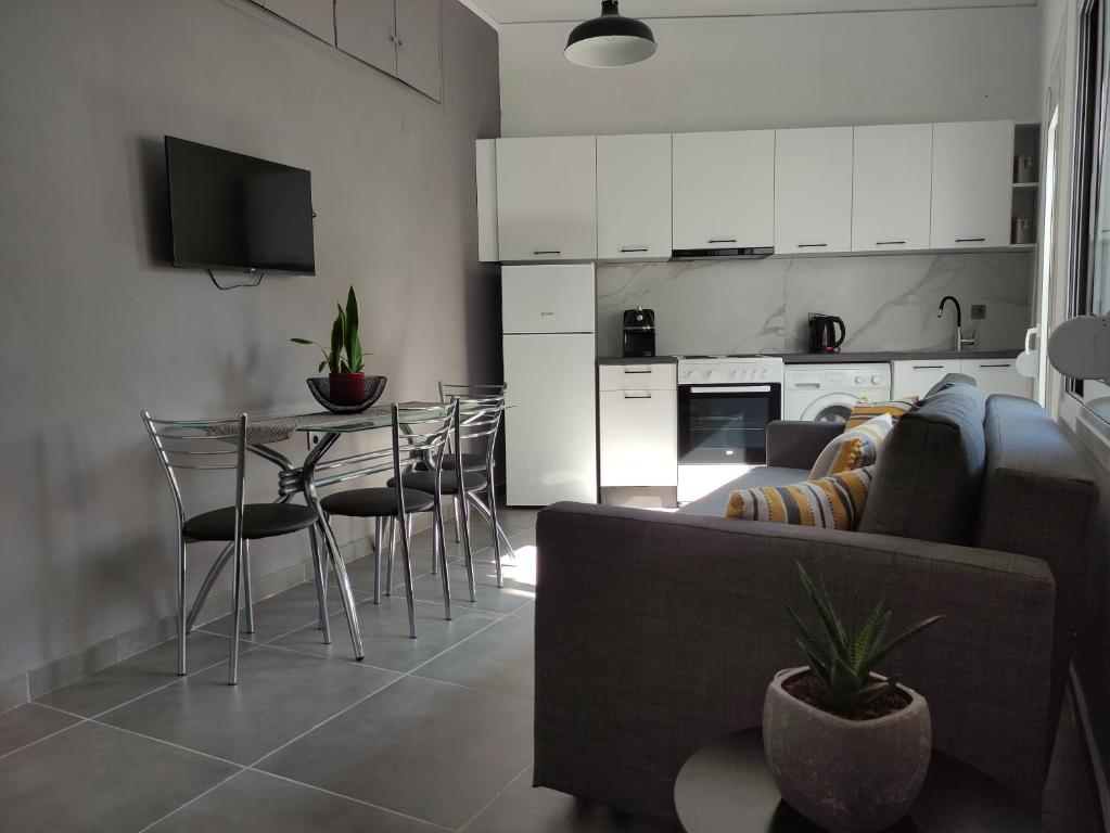 a living room with a couch and a table with chairs at Karavela Street Apartment in Preveza