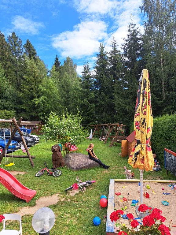 a park with a playground with toys and an umbrella at U Bernardýna in Harrachov