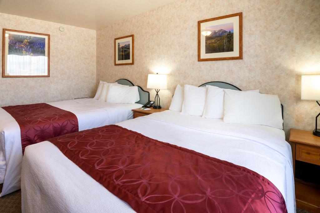 Habitación de hotel con 2 camas y 2 lámparas en Swiss Alps Inn, en Heber City