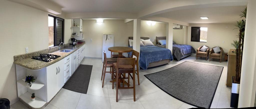 Cet appartement comprend une chambre avec un lit et une cuisine avec une table. dans l'établissement Espaço no Centro, à Lauro Müller