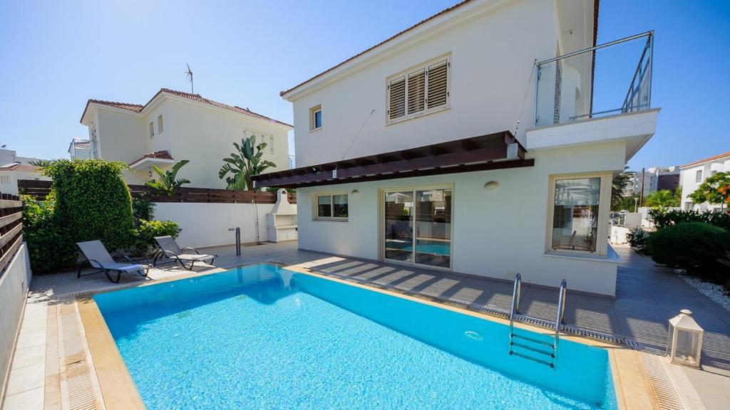 a swimming pool in front of a house at Pernera Holiday Villa 015 in Protaras