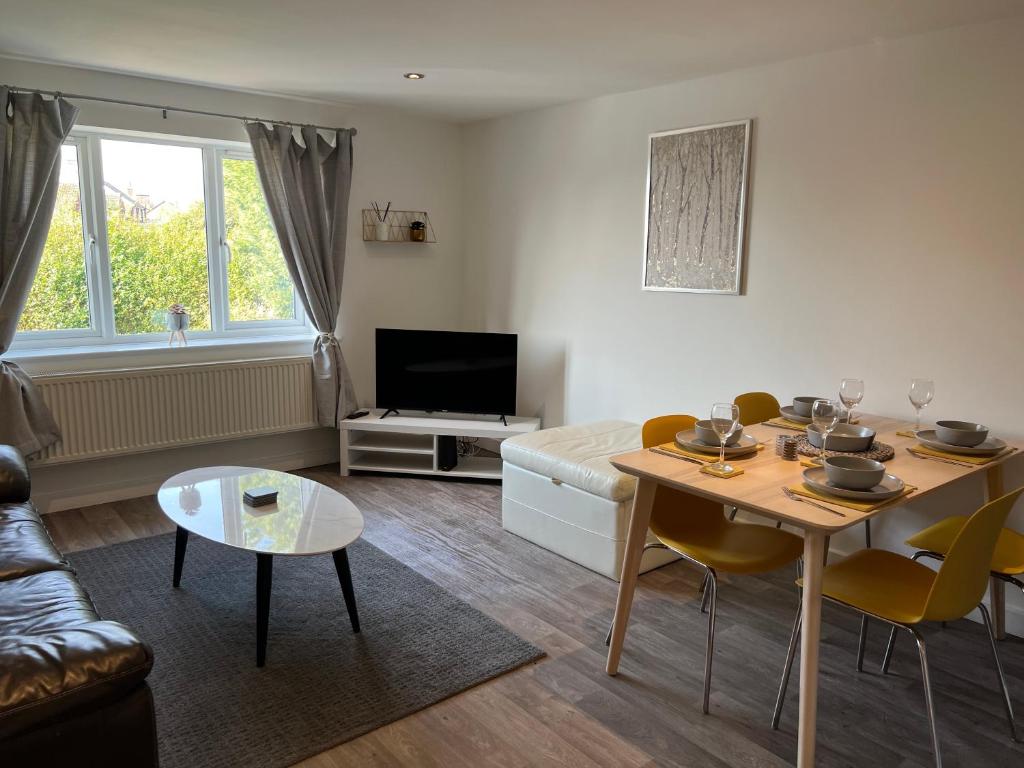 ein Wohnzimmer mit einem Tisch und einem Sofa in der Unterkunft The Aldridge 2 Bedroom Apartment with FREE Parking in Ibstock