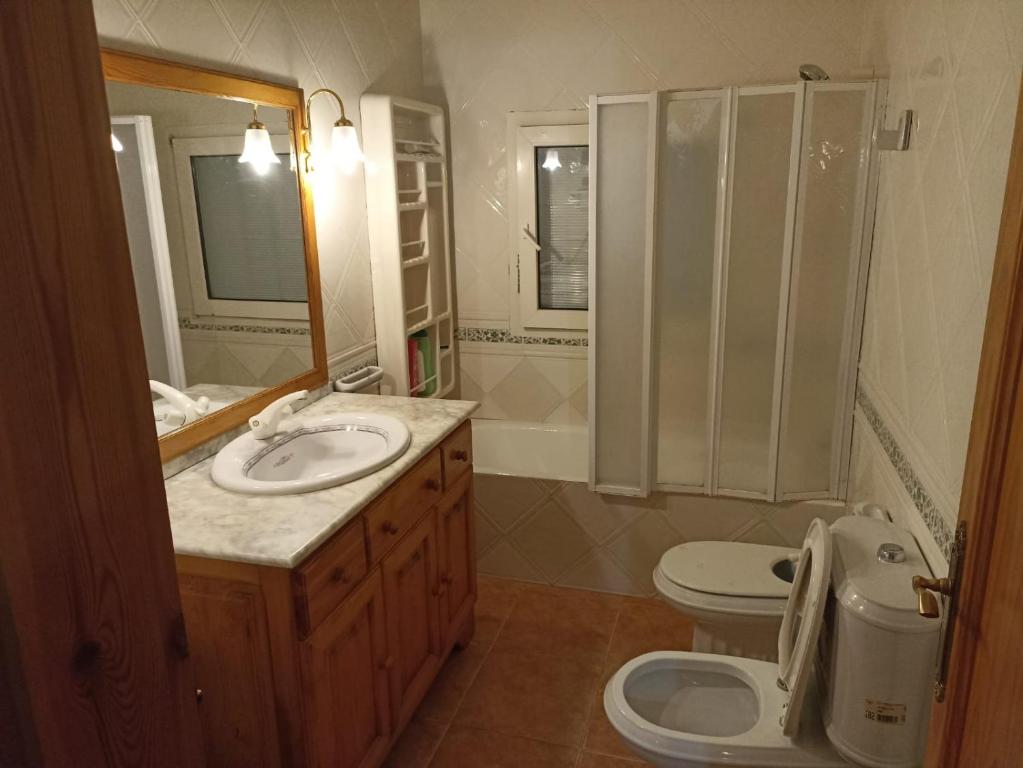 a bathroom with a sink and a toilet and a mirror at Chalet Mojácar Mícar 41 in Mojácar