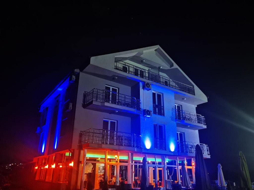 un edificio iluminado en azul y rojo en Sunrise Hotel & Camping, en Struga