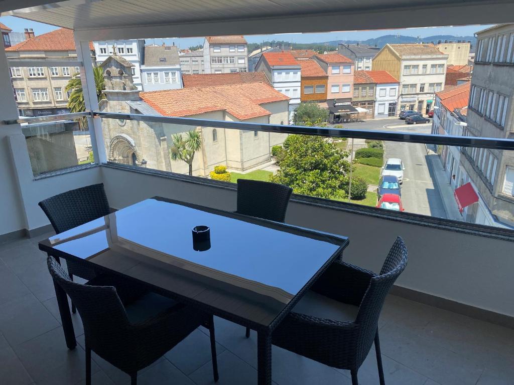 a table and chairs in a balcony with a view of a street at Gaia 1 in Melide