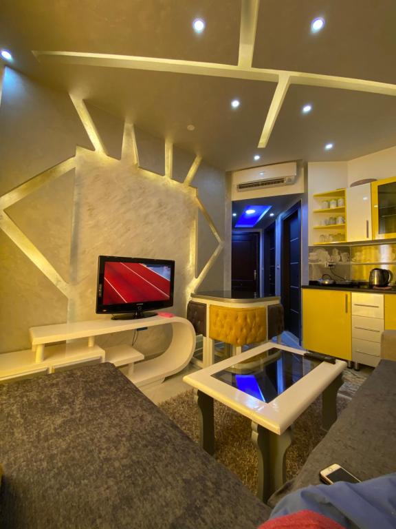 ein Wohnzimmer mit einem TV an der Wand in der Unterkunft أجمل شاليه فى بورتو مطروح للعائلات فقط in Marsa Matruh