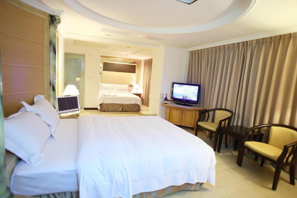 a hotel room with a large bed and a television at 享平方文旅 in Douliu
