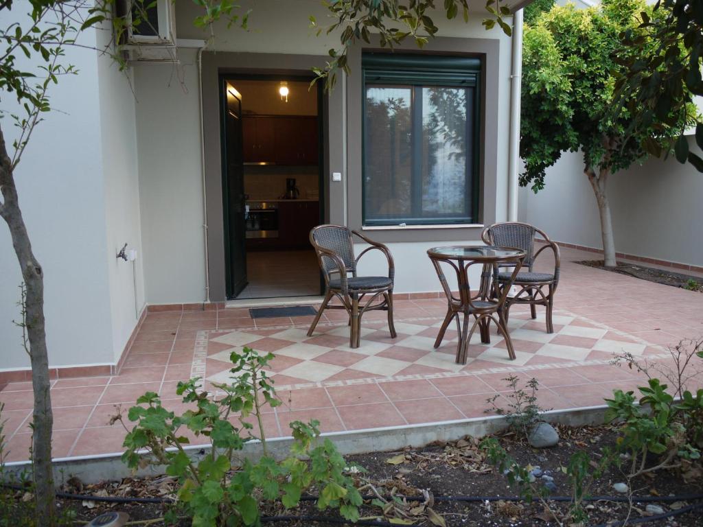a patio with chairs and a table on a brick patio at Portela Apartments Kampoula in Keratokampos