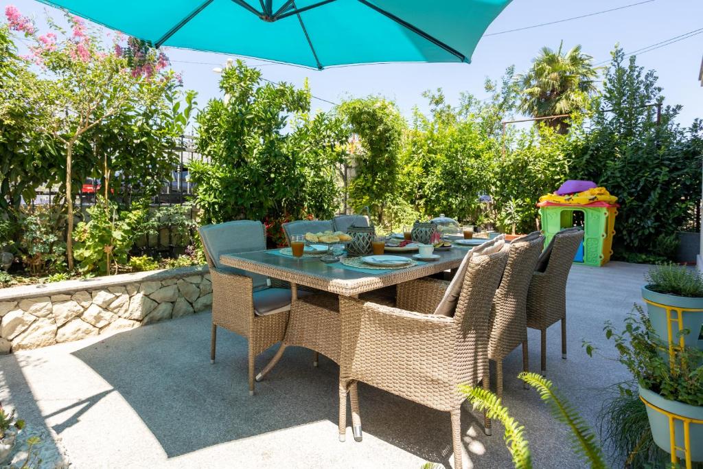 a patio with a table and chairs and an umbrella at Apartman Citromelo in Split