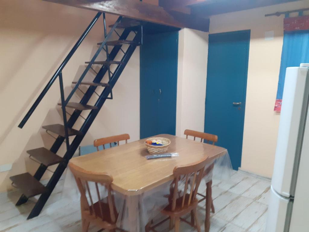 uma sala de jantar com uma mesa e uma escada em Los Marinos em Rosário