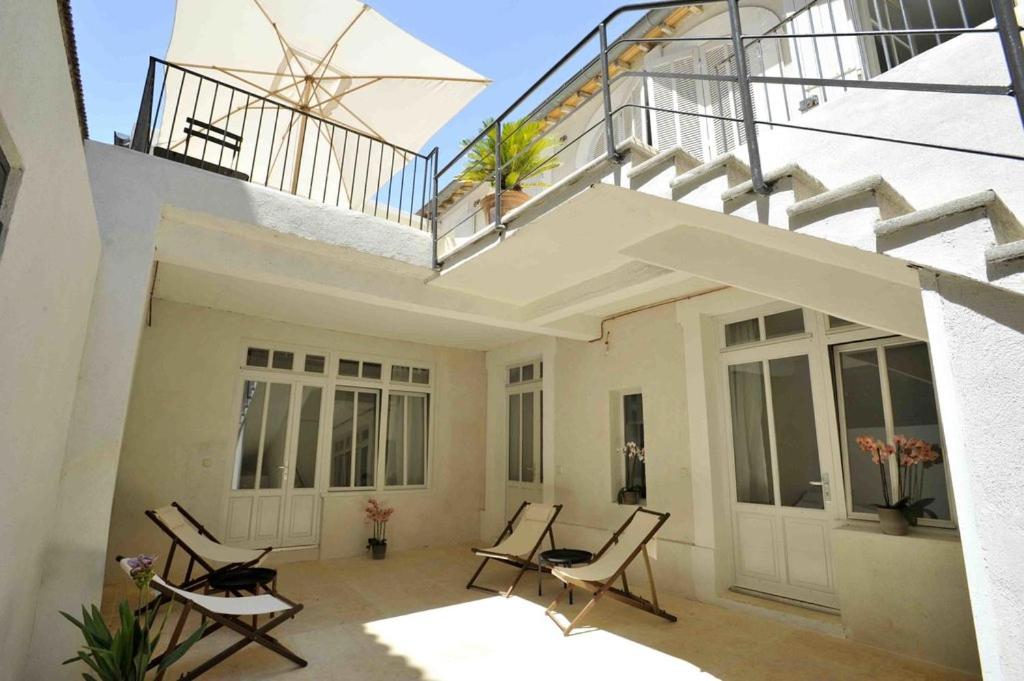 un patio con sedie e un balcone con scale. di Maison Boussingault ad Avignone