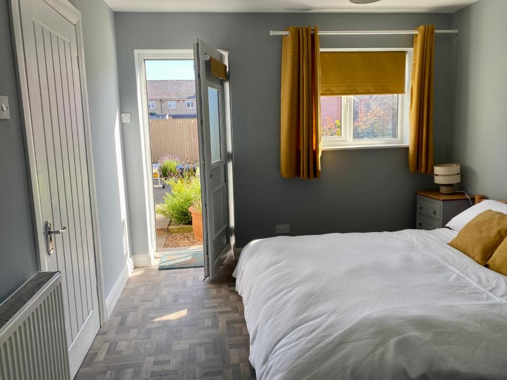 a bedroom with a white bed and a window at The Annexe in Filey