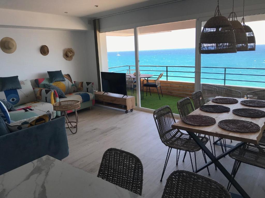 een woonkamer met een bank en een tafel en stoelen bij Panoramic sea view Lloret de Mar in Lloret de Mar