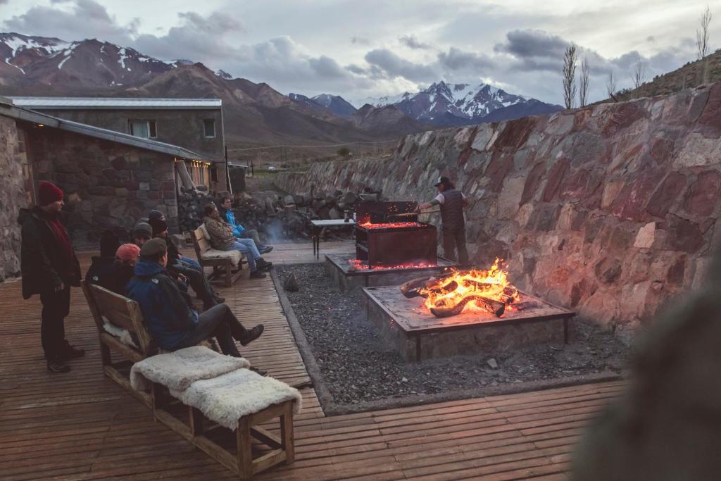 a group of people sitting around a fire pit at Las termas de los Molles in Los Molles