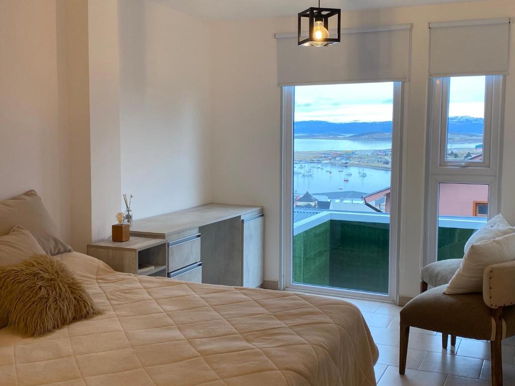 1 dormitorio con cama y ventana grande en BAHIA INFINITA en Ushuaia