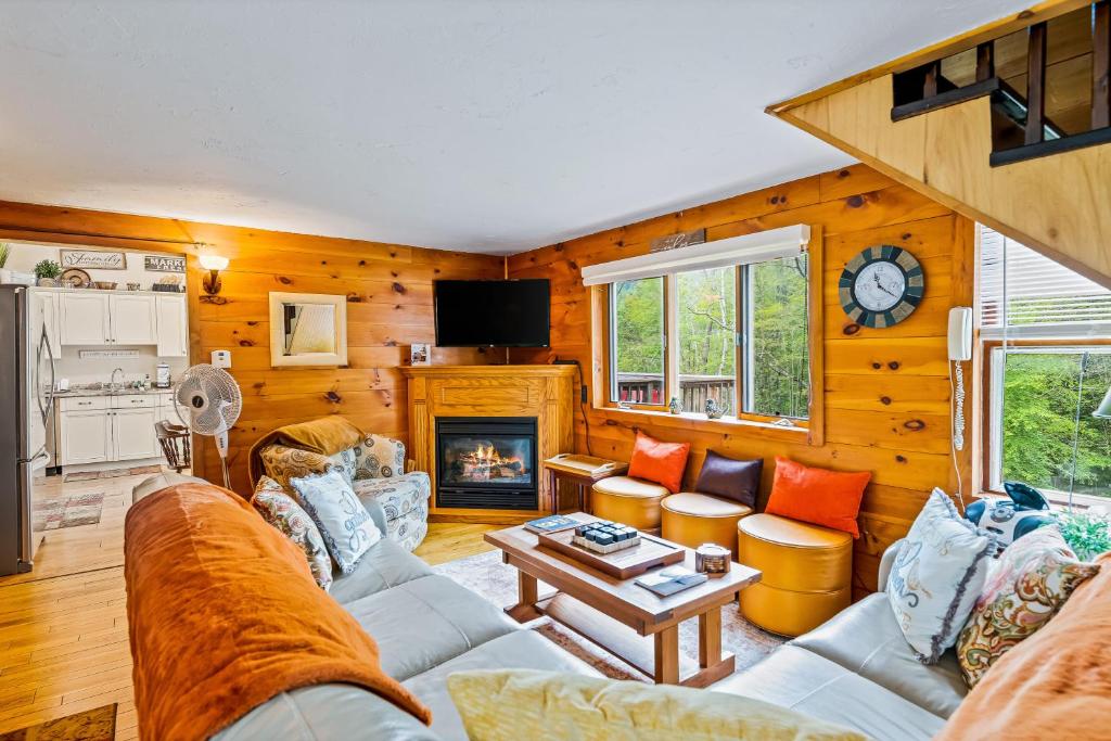 sala de estar con sofá y chimenea en Adirondack Sugar Shack, en Diamond Point