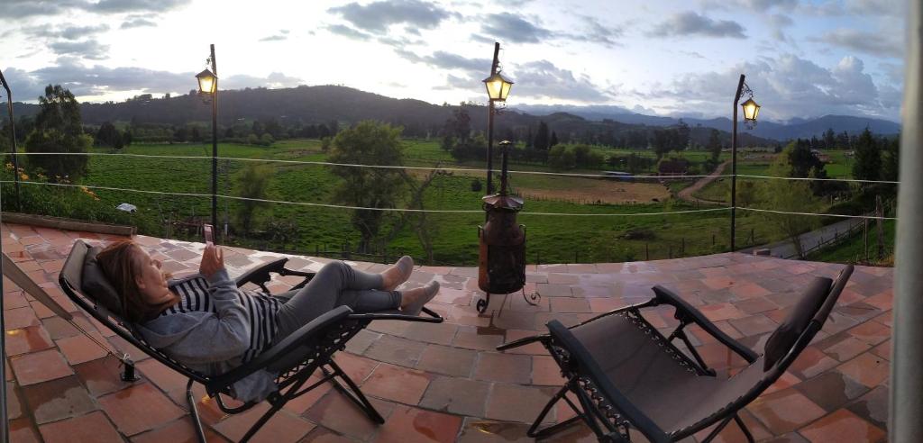 a woman laying in a chair on a patio at Glamping ILLARI Boutique in Paipa