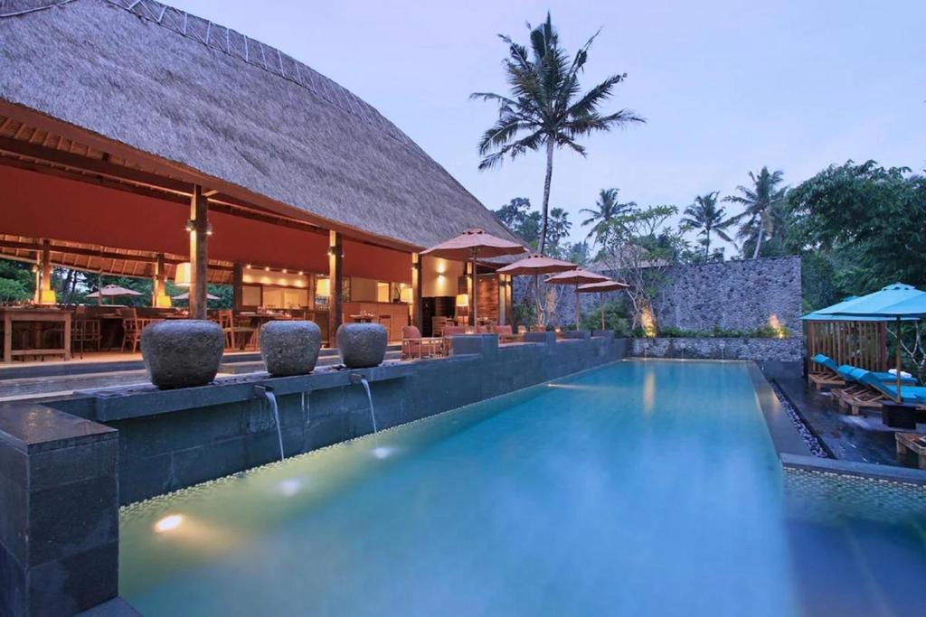 a large swimming pool with a large balcony at The Purist Villas & Spa Ubud in Ubud