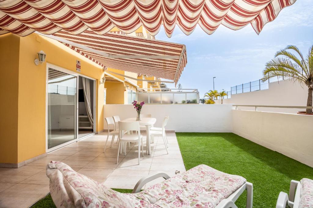 taras ze stołem i krzesłami na dachu w obiekcie Family Home near Ocean Los Cristianos LoveTenerife w Aronie