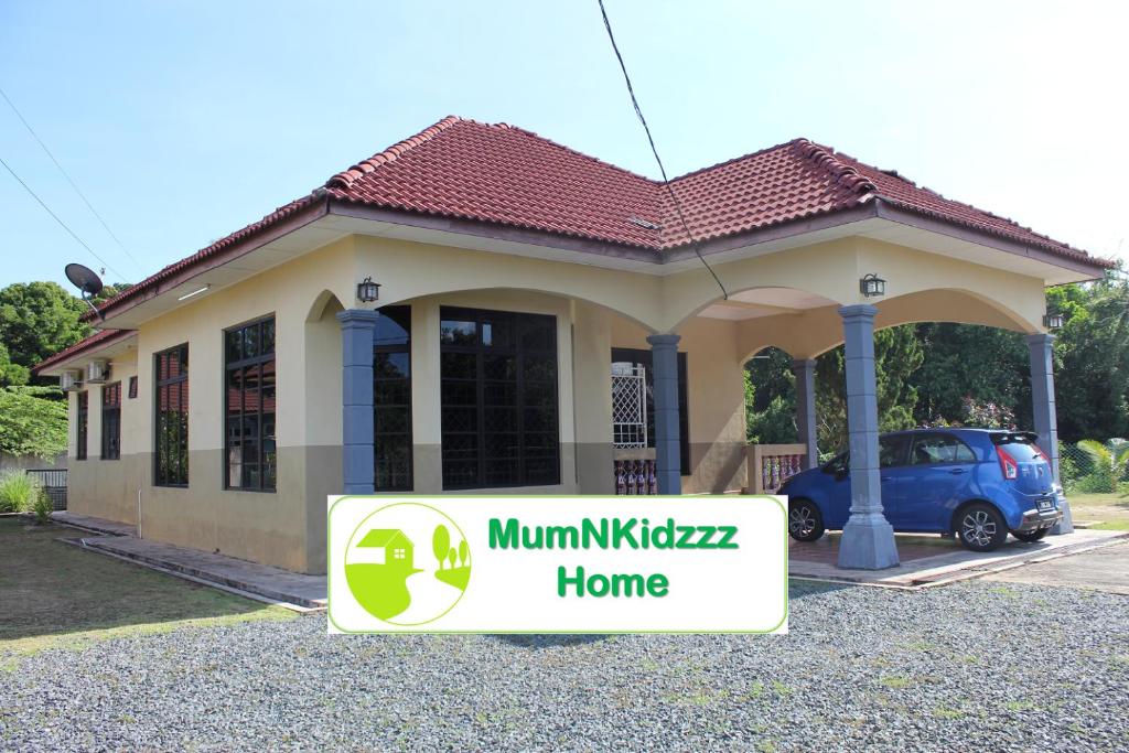 uma pequena casa com um sinal em frente em MumNKidzzz Homestay at Kerteh em Kampong Pengkalan Pangan