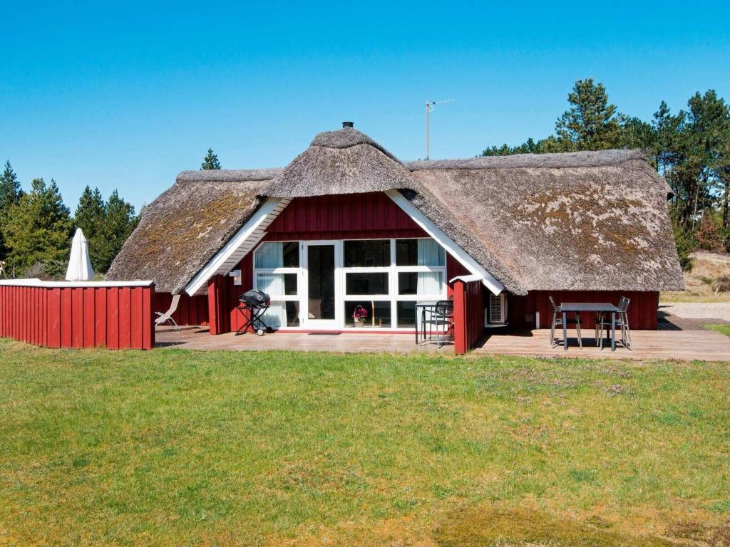 a small red building with a thatched roof at 8 person holiday home in R m in Kongsmark