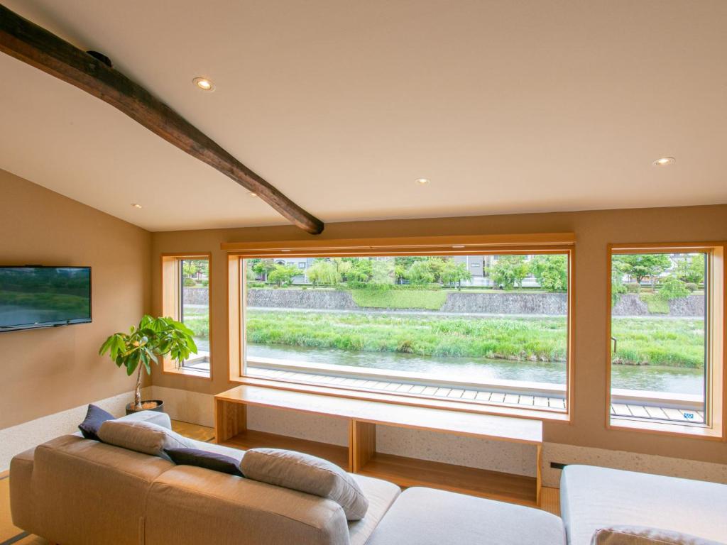 - un salon avec un canapé et une grande fenêtre dans l'établissement Shirasagi Kyoto, à Kyoto