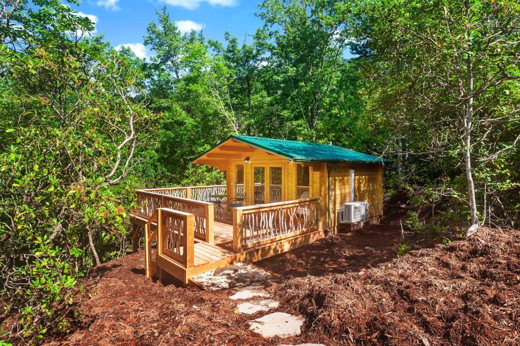 uma cabana na floresta com um telhado verde em Laurel Ridge Cabin...experience nature in 90 acres! em Marion