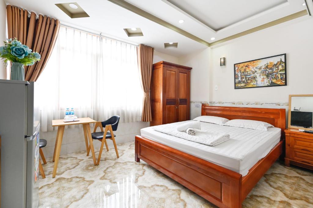 a bedroom with a bed and a desk and a television at Huyen House in Ho Chi Minh City