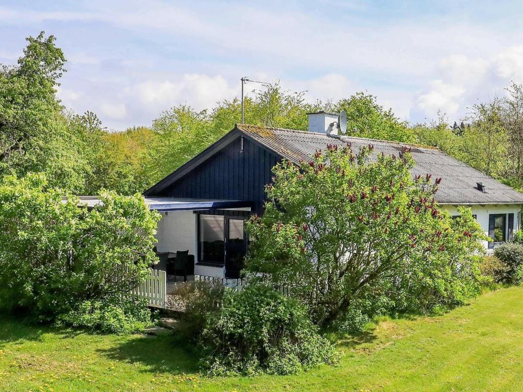 een zwart-wit huis met bomen ervoor bij 6 person holiday home in Sp ttrup in Spottrup